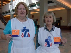 Photo of two women wearing white bibs with the Presbyterian seal