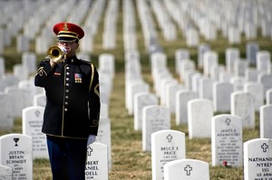 A lone U.S. Army bugler plays Taps at the conclusion of the First Annual Remembrance Ceremony in Dedication to Fallen Military Medical Personnel at Arlington National Cemetery.
