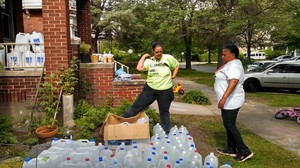 Valerie Jean Bailey and Monica Lewis-Patrick set up a We the People of Detroit water station.