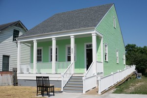 A newly constructed home in New Orleans’ Lower Ninth Ward neighborhood, built to historic preservation standards, is painted by a Project Homecoming workforce crew.