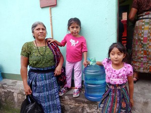 Guatemalan family receiving their first bottle of safe water from a new Living Waters for the World system.