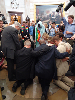 A group of religious leaders kneeling and prayer in the Capitol Hill Rotunda in Washington, D.C.