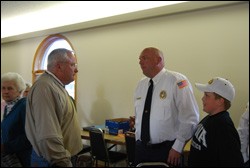 The fire chief of New London, IA, talks with members of New London Presbyterian Church at a recent community dinner sponsored by the congregation.