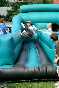 Kids enjoy an inflatable slide at Westminster’s block party. 