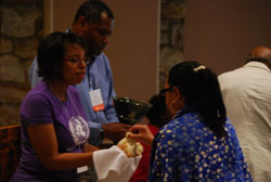 A woman receives communion from two people.