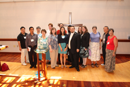 A group of seminary students dressed up, standing together in a chapel for a photo.