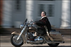 A pastor riding a motorcycle.