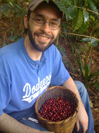 Benjamin Schellack holding a bushel of coffee beans.