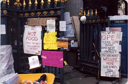 The exterior entrance of St. Paul's chapel, covered with signs, with packs of food near the entrance.