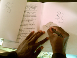 A pair of hands scribbling on a blank page in a book.