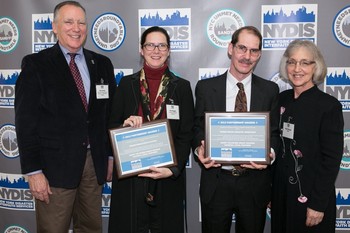 Ronald Drew (left), chair of the NYDIS board and Ruth Wenger (right),NYDIS executive vice-president present the NYDIS Partnership Award to Thia Reggio (second from left) on behalf of PDA and Robert Foltz-Morrison (second from right) of New York City Presbytery.