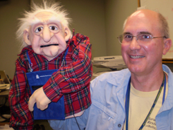 A man and a puppet, which appears to be of old age.