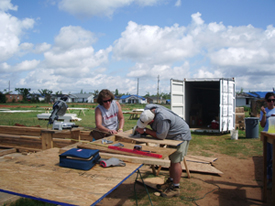 A group of volunteers working on a lumber at a site.