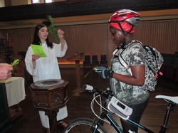Using a sprig of cedar, officiant Ann Russell sprinkles holy water on a bike and its rider at the sixth annual Blessing of the Bikes at Toronto’s Trinity-St. Paul’s United Church on June 7, 2015.