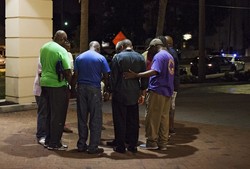  small prayer circle formed near where police responded to a shooting at the Emanuel AME Church in Charleston, S.C., on June 17, 2015. A gunman opened fire that evening at the historic African-American church in downtown Charleston.