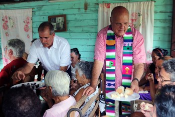 Ary Fernandez (left) and Edelberto Valdes serve communion to worshipers at the Presbyterian Mission at Marcane.