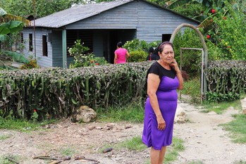 Cathy Reyes waits outside her home to greet worshipers at the Presbyterian Mission at Marcane.