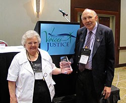 Photo of a man and woman holding an award