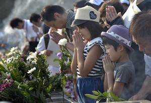 People praying on August 6, 2015, at a memorial in Hiroshima, Japan.