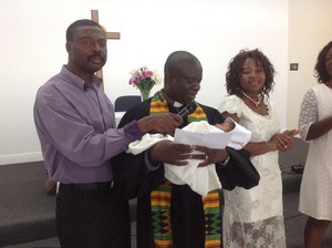 Pastor Ebenezer Boateng presents a child for baptism at Presbyterian Church of the Redeemer. The Ghanaian new worshiping community in Houston has an opportunity to grow, thanks to a new storefront worship space in a predominately new immigrant neighborhood.