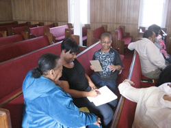 A small group of family members together, sitting in church pews.