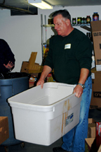 A man holding a large white bin.
