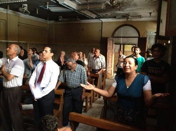 Members of Mallaway Presbyterian Church in Egypt held worship in their partially burned church days after it was set on fire by Islamist radicals.
