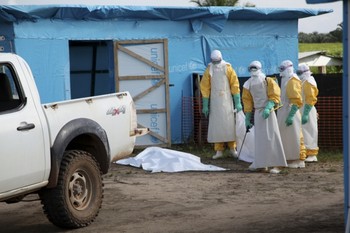 Health workers, wearing head-to-toe protective gear, prepare for work, outside an isolation unit in Foya District, Lofa County, Liberia in July.