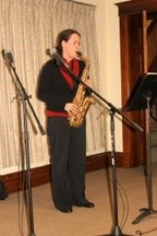 A woman in a church playing a saxophone.