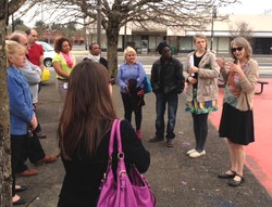 Jenny Holmes with Ecumenical Ministries of Oregon speaks with the Presbyterian Hunger Program Advisory Committee on the site of a future farmers market in the Rockwood community. 