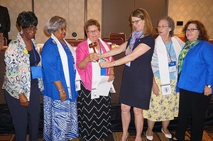 Mary Cook Jorgenson, 2012–2015 PW Churchwide moderator, (third from right) hands the ceremonial gavel to newly elected moderator Carol Winkler (third from left). Also pictured are Sheila Louder (far left), Wanda Beauman (second from left), Judy Persons (second from right) and Pam Snyder (far right.)
