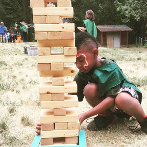 A camper plays a game of giant Jenga at Calvin Crest’s ‘Sherwood Forest’ camp experience.