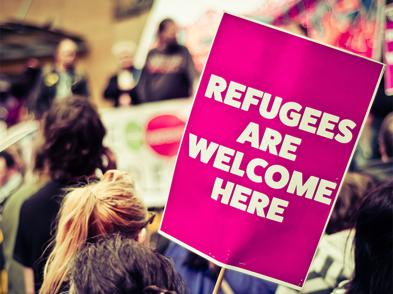 protester holding refugees welcome sign