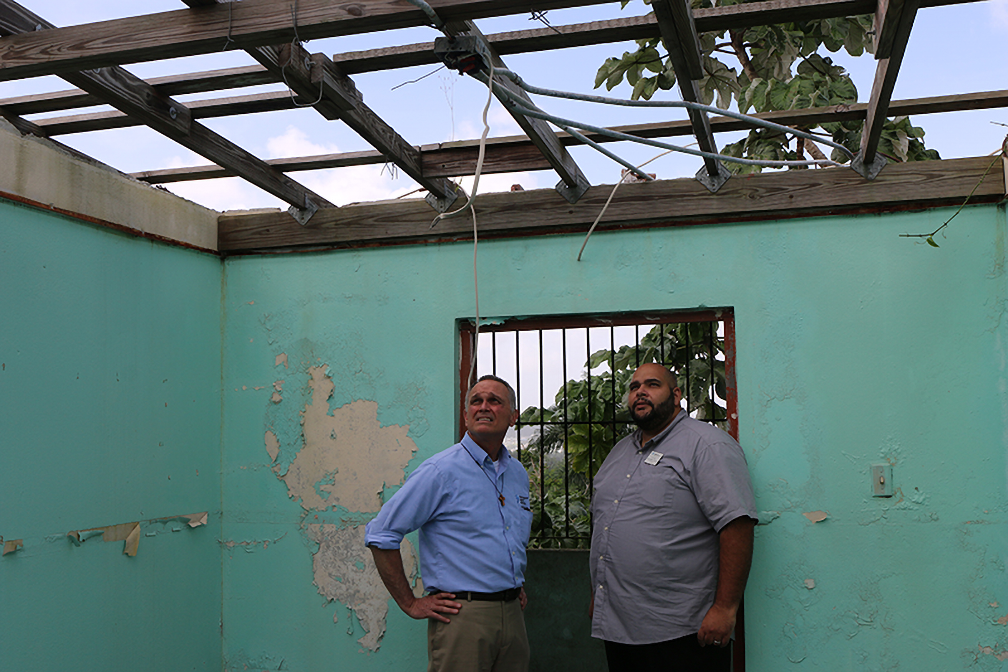 Rev. Dr. Jim Kirk and Rev. Edwin González-Castillo with PDA, review damage to a building the local church hopes will soon become a nurses’ station in Guaynabo. Photo by Rick Jones.