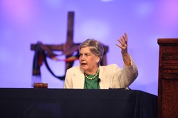 Cynthia Bolbach raises her hand for a blessing