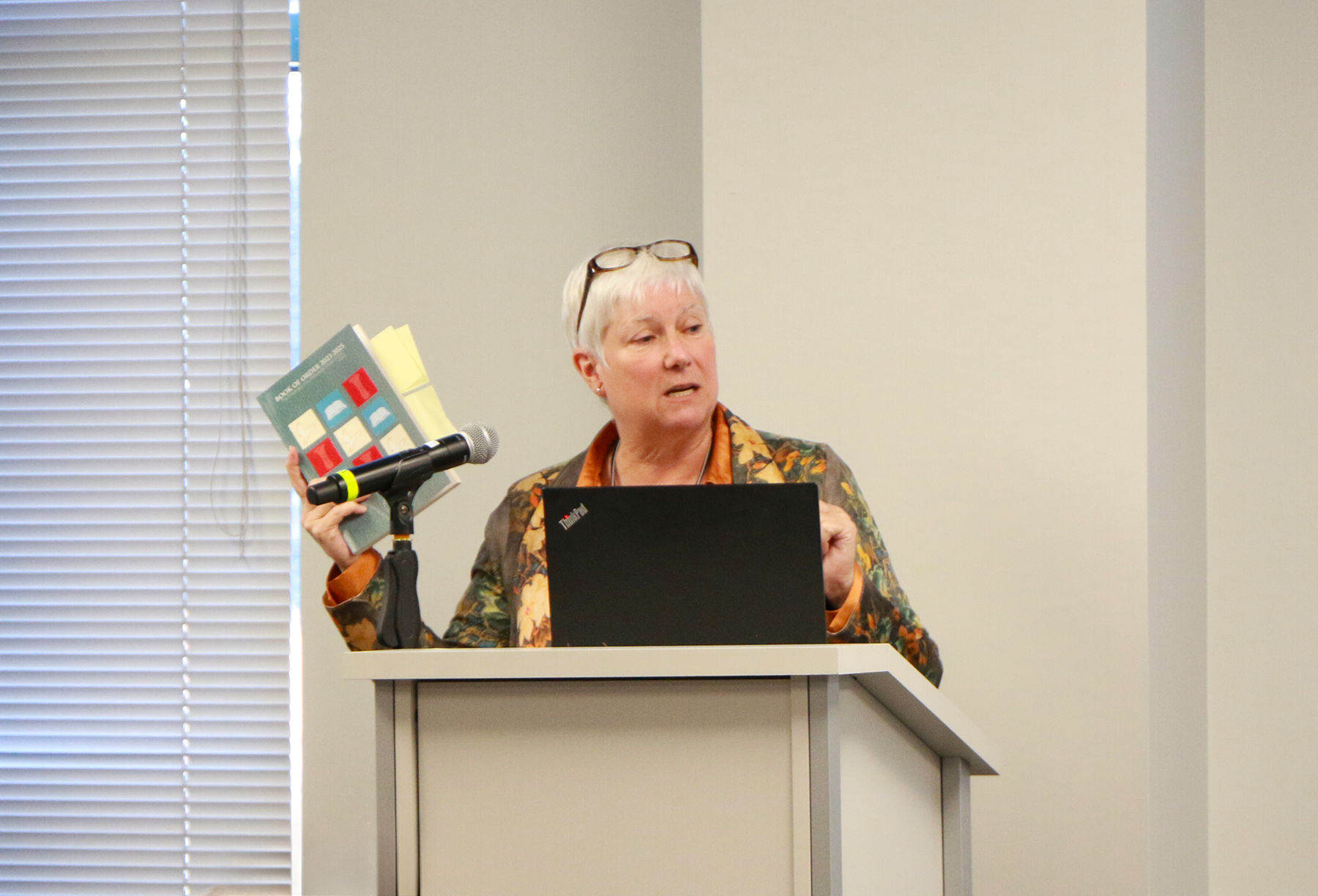 Laurie Griffith holding a Book of Order (2023-2025), November 10, 2023. Photo by Rick Jones.