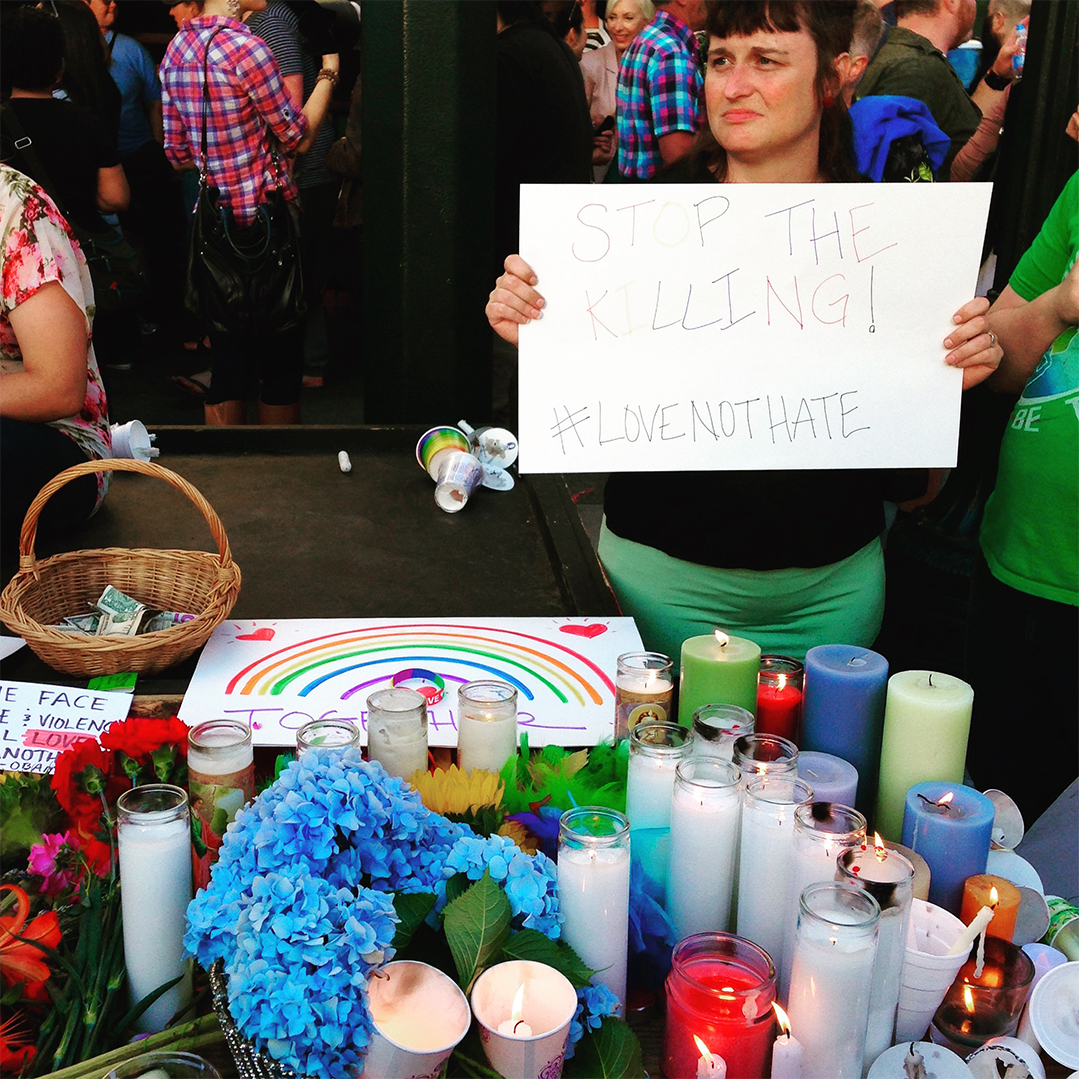 A table of candles and prayers at a vigil held in Portland, Oregon to commemorate the victims of the terrorist attack in Orlando's Pulse club in June 2016. Photo by Sarah Mirk
